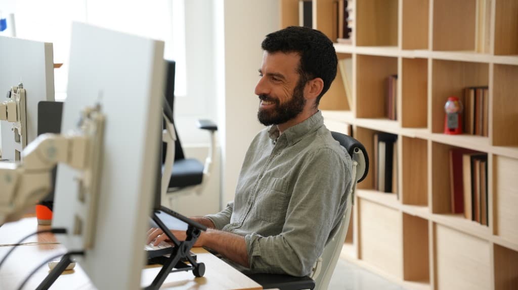 A Gumlooper working at a multi-monitor desk in the office